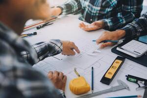 engineer people meeting working and pointing at a drawings in office for discussing. Engineering tools and construction concept. photo