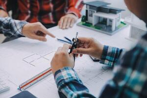 engineer people meeting working and pointing at a drawings in office for discussing. Engineering tools and construction concept. photo