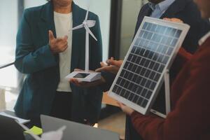 de cerca a tableta, ingenieros señalando a tableta con su manos. a conjuntamente diseño el utilizar de renovable energía con viento y solar energía. concepto de utilizando renovable energía. foto