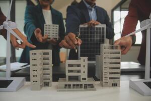 Close-up at tablet, Engineers pointing at tablet with their hands. To jointly design the use of renewable energy with wind and solar energy. Concept of using renewable energy. photo