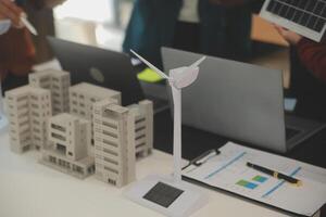 Close-up at tablet, Engineers pointing at tablet with their hands. To jointly design the use of renewable energy with wind and solar energy. Concept of using renewable energy. photo