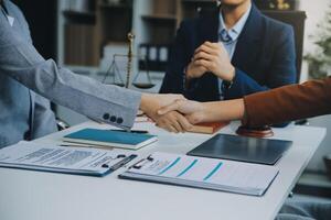 hombre de negocios dándose la mano para sellar un trato con sus socios abogados o abogados discutiendo un acuerdo de contrato. foto