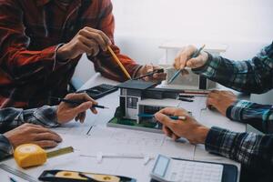 engineer people meeting working and pointing at a drawings in office for discussing. Engineering tools and construction concept. photo