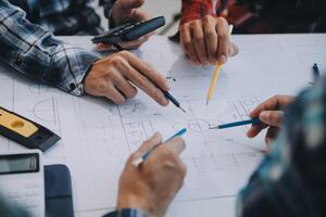 engineer people meeting working and pointing at a drawings in office for discussing. Engineering tools and construction concept. photo