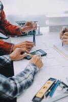 engineer people meeting working and pointing at a drawings in office for discussing. Engineering tools and construction concept. photo