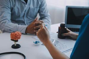 Doctor explaining brain functions to patient on model in office. photo