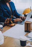 imagen de ingeniero reunión para arquitectónico proyecto. trabajando con compañero y Ingenieria herramientas en lugar de trabajo Clásico tono. foto