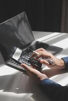 businessman working on desk office with using a calculator to calculate the numbers, finance accounting concept photo