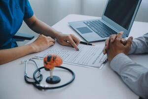 Doctor explaining brain functions to patient on model in office. photo