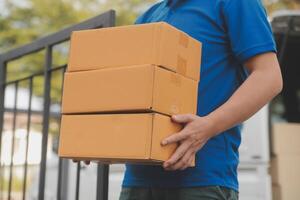 Asian delivery express courier young man use giving boxes to woman customer he wearing protective face mask at front home photo