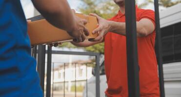 Asian delivery express courier young man use giving boxes to woman customer he wearing protective face mask at front home photo