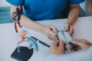 Doctor uses anatomical model to explain male urinary system. Model labeled with parts, doctor points and explains how they work together for urinary function, ensuring patient comprehension. photo