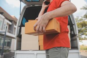 Asian delivery express courier young man use giving boxes to woman customer he wearing protective face mask at front home photo