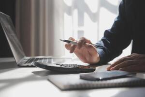 businessman working on desk office with using a calculator to calculate the numbers, finance accounting concept photo
