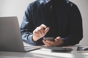 lado ver Disparo de un del hombre manos utilizando inteligente teléfono en interior, posterior ver de negocio hombre manos ocupado utilizando célula teléfono a oficina escritorio, joven masculino estudiante mecanografía en teléfono sentado a de madera mesa, llamarada foto