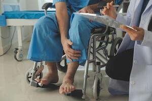 young asian physical therapist working with senior woman on walking with a walker photo