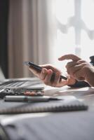 Side view shot of a man's hands using smart phone in interior, rear view of business man hands busy using cell phone at office desk, young male student typing on phone sitting at wooden table, flare photo