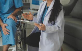 young asian physical therapist working with senior woman on walking with a walker photo