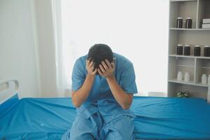 A male patient suffering from stress, migraines, eye strain, headaches, eye problems from working hard and not getting enough rest receives treatment from a doctor at the hospital. photo