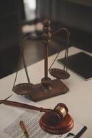 image of judge's hammer, scales lady of justice, law book, laptop computer and contract documents with pen concept of law and justice. photo