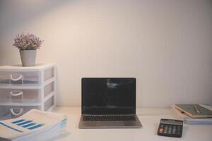 Laptop and paperwork on conference table photo