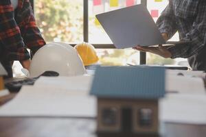 A team of construction engineers talks to managers and construction workers at the construction site. Quality inspection, work plan, home and industrial building design project photo