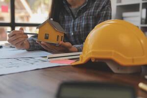 A team of construction engineers talks to managers and construction workers at the construction site. Quality inspection, work plan, home and industrial building design project photo