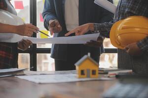 A team of construction engineers talks to managers and construction workers at the construction site. Quality inspection, work plan, home and industrial building design project photo