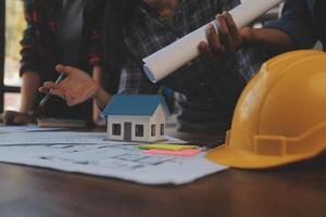 A team of construction engineers talks to managers and construction workers at the construction site. Quality inspection, work plan, home and industrial building design project photo