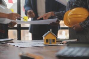 A team of construction engineers talks to managers and construction workers at the construction site. Quality inspection, work plan, home and industrial building design project photo