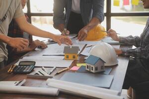 A team of construction engineers talks to managers and construction workers at the construction site. Quality inspection, work plan, home and industrial building design project photo