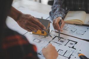 un equipo de construcción ingenieros negociaciones a gerentes y construcción trabajadores a el construcción sitio. calidad inspección, trabajo plan, hogar y industrial edificio diseño proyecto foto