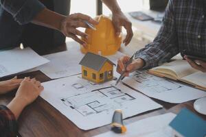 A team of construction engineers talks to managers and construction workers at the construction site. Quality inspection, work plan, home and industrial building design project photo