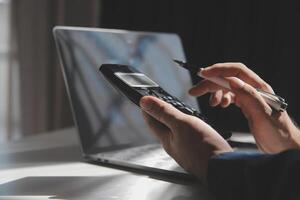 businessman working on desk office with using a calculator to calculate the numbers, finance accounting concept photo