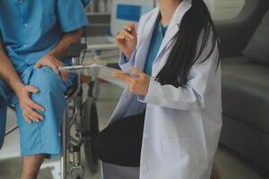 young asian physical therapist working with senior woman on walking with a walker photo