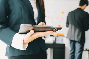 Business team working with new startup project plan and discussion information for financial strategy with laptop and digital tablet in a modern business lounge. photo