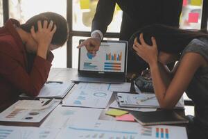 Frustrated upset multiracial business team people sad with bad work result in report disappointed in corporate bankruptcy failure crisis worried of paperwork problem sit at table at office meeting photo