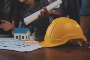 A team of construction engineers talks to managers and construction workers at the construction site. Quality inspection, work plan, home and industrial building design project photo