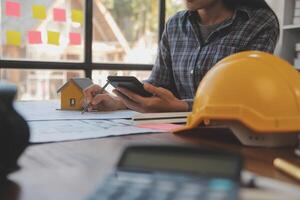 un equipo de construcción ingenieros negociaciones a gerentes y construcción trabajadores a el construcción sitio. calidad inspección, trabajo plan, hogar y industrial edificio diseño proyecto foto