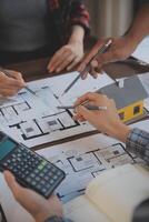 A team of construction engineers talks to managers and construction workers at the construction site. Quality inspection, work plan, home and industrial building design project photo