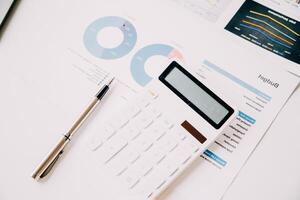 Financial analysts analyze business financial reports on a digital tablet planning investment project during a discussion at a meeting of corporate showing the results of their successful teamwork. photo