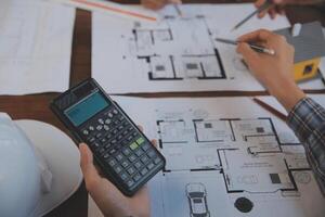 A team of construction engineers talks to managers and construction workers at the construction site. Quality inspection, work plan, home and industrial building design project photo