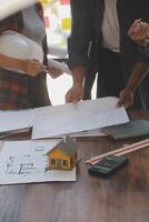 A team of construction engineers talks to managers and construction workers at the construction site. Quality inspection, work plan, home and industrial building design project photo