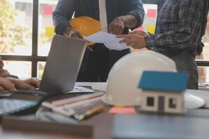 A team of construction engineers talks to managers and construction workers at the construction site. Quality inspection, work plan, home and industrial building design project photo