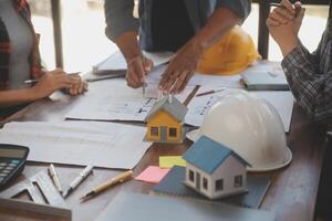 A team of construction engineers talks to managers and construction workers at the construction site. Quality inspection, work plan, home and industrial building design project photo