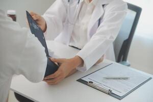 Male doctor uses a blood pressure monitor to check the body pressure and pulse of the patients who come to the hospital for check-ups, Medical treatment and health care concept. photo