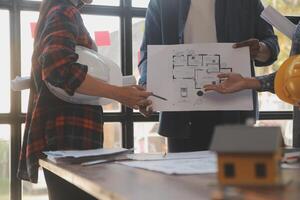 A team of construction engineers talks to managers and construction workers at the construction site. Quality inspection, work plan, home and industrial building design project photo