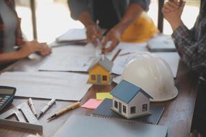 A team of construction engineers talks to managers and construction workers at the construction site. Quality inspection, work plan, home and industrial building design project photo