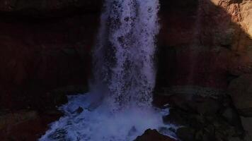 Small waterfall in the rocky gorge. Closeup filmed by drone video