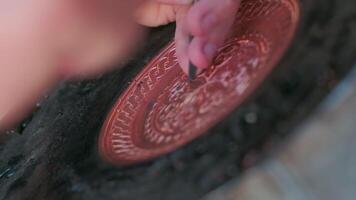 Bukhara master engraves patterns on a tray. Close up video